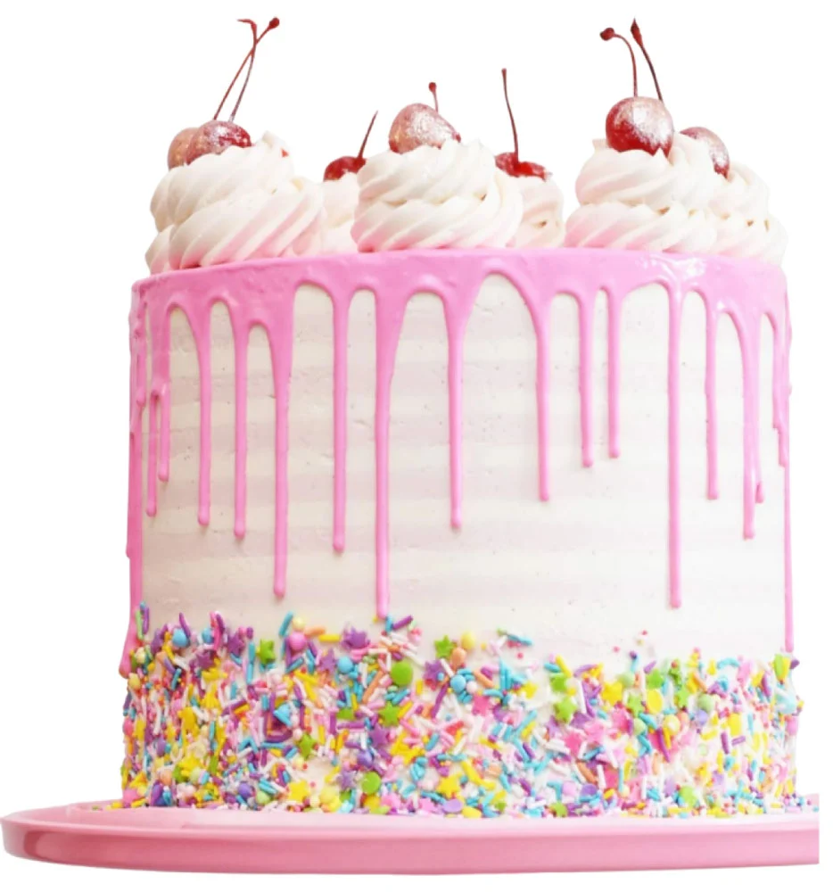 A colorful cake with pink icing drips, topped with whipped cream and cherries. The bottom edge is coated in multicolored sprinkles, and it sits on a matching pink plate.